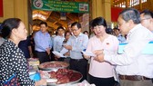 Đoàn giám sát HĐNDTP kiểm tra giấy chứng nhận nguồn gốc thịt heo tại chợ Bến Thành. Ảnh: HOÀNG HÙNG