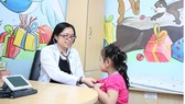   Bác sĩ Huỳnh Thị Vũ Quỳnh đang thăm khám cho trẻ