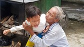 Ông Chinh đang dỗ dành đứa cháu nội  tật nguyền