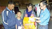 Đại diện các đoàn thể Trường Tiểu học Trần Quốc Toản tặng quà năm học mới giúp cháu Sơn