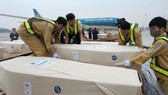 Nhân viên sân bay quốc tế Nội Bài vận chuyển thi thể các nạn nhân lên ôtô để đưa về quê nhà. Ảnh: TTXVN