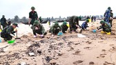 Lực lượng chức năng thu gom cặn dầu loang trên bờ biển xã Kỳ Lợi, Hà Tĩnh 