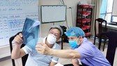 Thứ trưởng Bộ Y tế Nguyễn Trường Sơn (trái) trực tiếp theo dõi  tình hình sức khỏe bệnh nhân Covid-19 tại Bệnh viện Phổi Đà Nẵng. Ảnh: NGUYỄN CƯỜNG