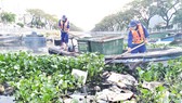 Công nhân Công ty Môi trường đô thị TPHCM vớt rác trên tuyến kênh Tân Hóa - Lò Gốm