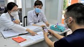 Bác sĩ thực tập Nguyễn Thị Quỳnh Trang khám, tư vấn cho người dân  tại Trạm y tế phường Hiệp Thành, quận 12. Ảnh: QUANG HUY
