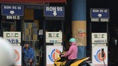 Tại một trạm xăng ở quận Bình Tân, TP.HCM, nhân viên ngồi ra hiệu hết xăng khi khách đến mua (ảnh chụp chiều 21-2) - Ảnh: T.T.D.