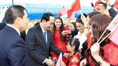 Cán bộ, nhân viên Đại sứ quán Việt Nam và đại diện cộng đồng người Việt Nam tại Cộng hòa Belarus đón Chủ tịch nước Trần Đại Quang và phu nhân tại sân bay Quốc tế Minsk