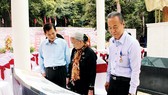 Nguyên Chủ tịch nước Nguyễn Minh Triết (bìa trái) và các đại biểu xem lịch sử hình thành di tích Căn cứ Dân Chính đảng Trung ương Cục miền Nam