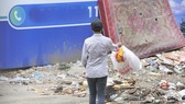 Vô tư vứt rác vào một bãi rác tự phát   Ảnh: THÀNH TRÍ