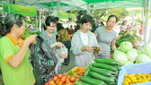 Người dân mua nông sản an toàn tại chợ phiên ở Công viên Lê Thị Riêng sáng 24-9-2017. Ảnh tư liệu: CAO THĂNG