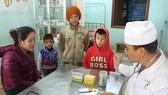 Quân y của Trạm quân dân y kết hợp Thoọng Pẹ đang thăm khám cho trẻ em trong bản và hướng dẫn cho các bậc phụ huynh các phòng tránh bệnh cho con em. Ảnh: Báo Hà Tĩnh