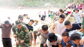 Lực lượng biên phòng, dân quân tự vệ và người dân nỗ lực sửa chữa kè biển xã Nhơn Hải, Bình Định. Ảnh: NGỌC OAI