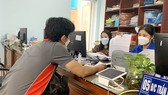 Cán bộ, công chức phường Hiệp Bình Chánh (TP Thủ Đức, TPHCM) giải quyết hồ sơ cho người dân. Ảnh: THU HƯỜNG