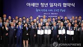 President Moon Jae-in (front row, fifth from R) poses for a group photo in a ceremony held in Hanoi on March 23, 2018 to mark the launch of a new job creation campaign by South Korean businesses in Vietnam and other member countries of the Association of 