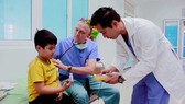 Bác sĩ James Nguyen và bác sĩ David Paul Norton (giữa) khám bệnh cho bé Ân tại Bệnh viện Sản nhi Quảng Ngãi