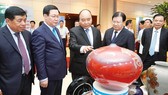 Thủ tướng Nguyễn Xuân Phúc tham quan các gian hàng trưng bày sản phẩm trong khuôn khổ hội nghị Ảnh: VIẾT CHUNG