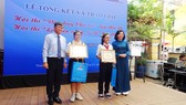 Bà Lý Việt Trung, Phó Tổng biên tập Báo SGGP (ngoài cùng bên phải) và ông Nguyễn Văn Hiếu, Phó Giám đốc Sở GD-ĐT TPHCM (ngoài cùng bên trái) trao thưởng cho 2 học sinh đoạt giải nhất hội thi “Văn hay chữ tốt”
