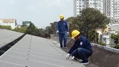 Nhân viên EVNHCMC lắp đặt điện mặt trời trên mái nhà cho một đơn vị thuộc ngành điện lực