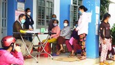 Người dân phường Hoài Xuân, thị xã Hoài Nhơn, Bình Định đến trạm y tế nộp tiền test Covid-19  vào chiều 29-12 để được tiêm vaccine