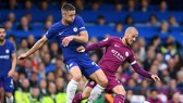 Gary Cahill (trái, Chelsea) tranh bóng với David Silva (Manchester City)