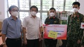 Đồng chí Dương Ngọc Hải tặng quà động viên lực lượng y, bác sĩ làm nhiệm vụ tại một trạm y tế lưu động ở quận Tân Phú. Ảnh: ĐÌNH LÝ