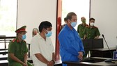 Bị cáo Phạm Văn Cung (áo xanh) và bị cáo Nguyễn Tuấn Sĩ tại phiên tòa sơ thẩm. Ảnh: QUỐC AN