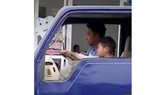 Thiếu niên hướng dẫn em bé 8 tuổi điều khiển xe tải (ảnh cắt từ clip)
