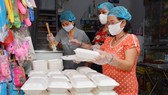 Một gia đình ở quận Phú Nhuận, TPHCM nấu cơm phát từ thiện cho người nghèo và ở bệnh viện, sáng 7-4-2020. Ảnh: VIỆT DŨNG