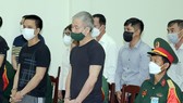 Bị cáo Lê Văn Minh (áo đen, tóc bạc) tại phiên tòa vào ngày 14-7. Ảnh: THÔNG TẤN QUÂN SỰ