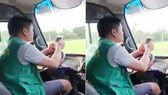 Hình ảnh tài xế xe buýt vừa lái xe vừa lướt điện thoại. Ảnh cắt từ clip.