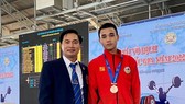 Cựu lực sĩ Hoàng Anh Tuấn (trái) giờ đã là một trọng tài và HLV ở các giải cử tạ trong nước. Ảnh: HA.TUẤN