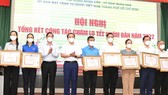 Secretary of HCMC Party Committee Nguyen Van Nen and Chairman of HCMC People’s Committee Phan Van Mai are delivering certificates of merit to groups who are excellent in Tet preparation tasks. (Photo: SGGP)
