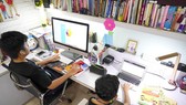Hai em Nguyễn Huỳnh Bách (lớp 7 Trường THCS Đinh Thiện Lý) và Nguyễn Huỳnh Thông (lớp 3 Trường Tiểu học Võ Thị Sáu) học trực tuyến tại nhà. Ảnh: THANH TÙNG