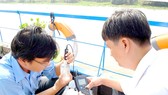Lực lượng chức năng ở TPHCM kiểm tra chất lượng nước lấy từ sông Sài Gòn đoạn qua huyện Củ Chi. Ảnh: CAO THĂNG