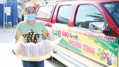 Người dân hẻm 54 Hồ Học Lãm, phường 16 (quận 8) nhận gạo hỗ trợ từ Báo SGGP. Ảnh: DŨNG PHƯƠNG