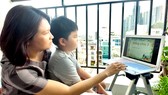 Mẹ kèm con học online tại nhà. Ảnh: DŨNG PHƯƠNG