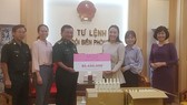 Đại diện Công ty Mỹ phẩm thương hiệu Việt M.O.I Cosmetics trao bảng tượng trưng số tiền tặng Bộ đội biên phòng