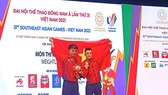 Lại Gia Thành (phải) chia sẻ niềm vui cùng người thầy của mình. Ảnh: NGUYỄN ANH
