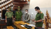 Lực lượng công an đọc lệnh khám xét nhà và bắt giữ đối tượng Nguyễn Hồ Hát. Ảnh: CACC