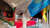 Nhân viên ở Trung tâm báo chí SEA Games 31 căng chỉnh lại cờ Đại hội. ẢNH: DŨNG PHƯƠNG