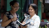 Bí thư chi bộ đồng thời là Trưởng khu phố 4, phường 1, quận 3 Nguyễn Thị Chiếm (bên phải) trao đổi với người dân trong khu phố