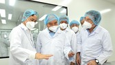 Chủ tịch nước Nguyễn Xuân Phúc và Bí thư Thành ủy TPHCM Nguyễn Văn Nên nghe giới thiệu về vaccine Nano Covax. Ảnh: VIỆT DŨNG