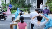 Nhân viên y tế lấy mẫu xét nghiệm cộng đồng người dân trong khu vực “vùng xanh” phường Phước Long, TP Nha Trang. Ảnh: QUỲNH ANH