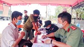 Lực lượng chức năng kiểm tra giấy tờ của người dân tại chốt kiểm soát trên Quốc lộ 1A, TP Cam Ranh. Ảnh: QUỲNH ANH