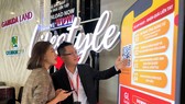 Nhân viên Gamuda Land hướng dẫn khách hàng cài đặt app tại khu nhà mẫu trưng bày