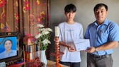 Chủ tịch MTTQVN xã Tân Ninh Nguyễn Duy Hợi trao số tiền 30 triệu đồng của bạn đọc Báo SGGP đến cháu Hoàng Quốc Dương, con trai đầu của chị Hoạt 