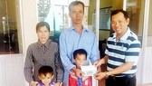 Đại diện Báo SGGP (bên phải) trao 16,7 triệu đồng của bạn đọc Báo SGGP hỗ trợ gia đình chị Thu Vân để có điều kiện trị bệnh và đón tết 