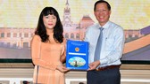 Chủ tịch UBND TPHCM Phan Văn Mãi trao quyết định cho đồng chí Phạm Thị Hồng Hà. Ảnh: VIỆT DŨNG