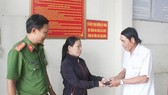 Chị Lê Thị Hậu trao trả lại tài sản cho người đánh rơi tại Công an phường Thanh Bình, TP Biên Hòa. Ảnh: TTXVN