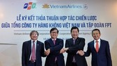 Representatives of Vietnam Airlines and FPT Corporation shake hands after signing strategic co-operation agreement in Hanoi. (Photo: VNA)